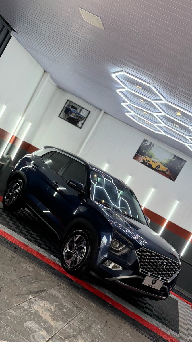 SUV azul escuro com reflexo da iluminação em favo de mel